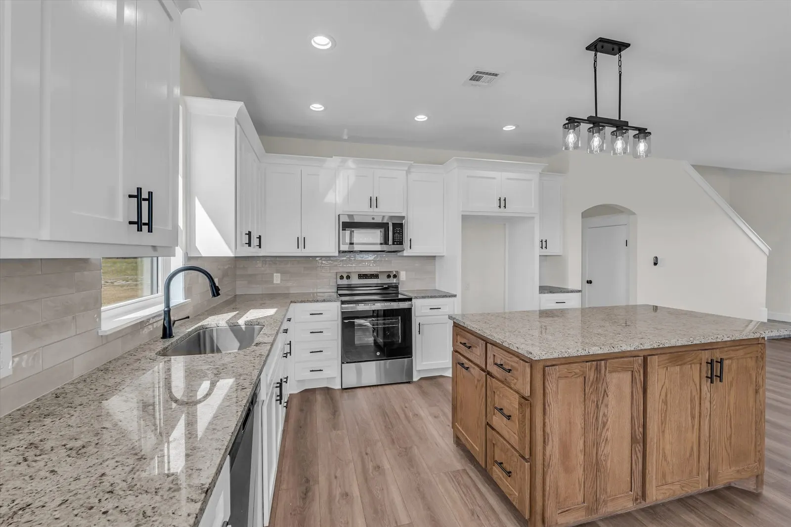 High angle view of the modern kitchen with custom cabinetry and granite countertops
