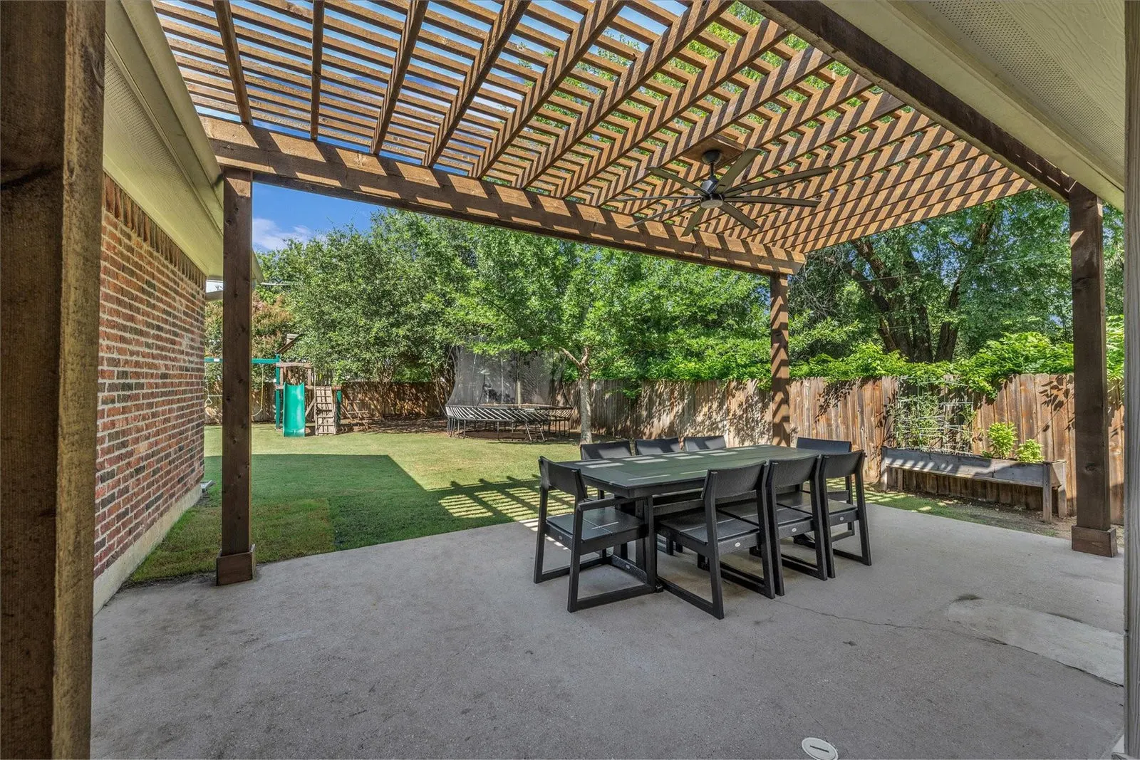 Wide angle view of a charming backyard with a covered patio