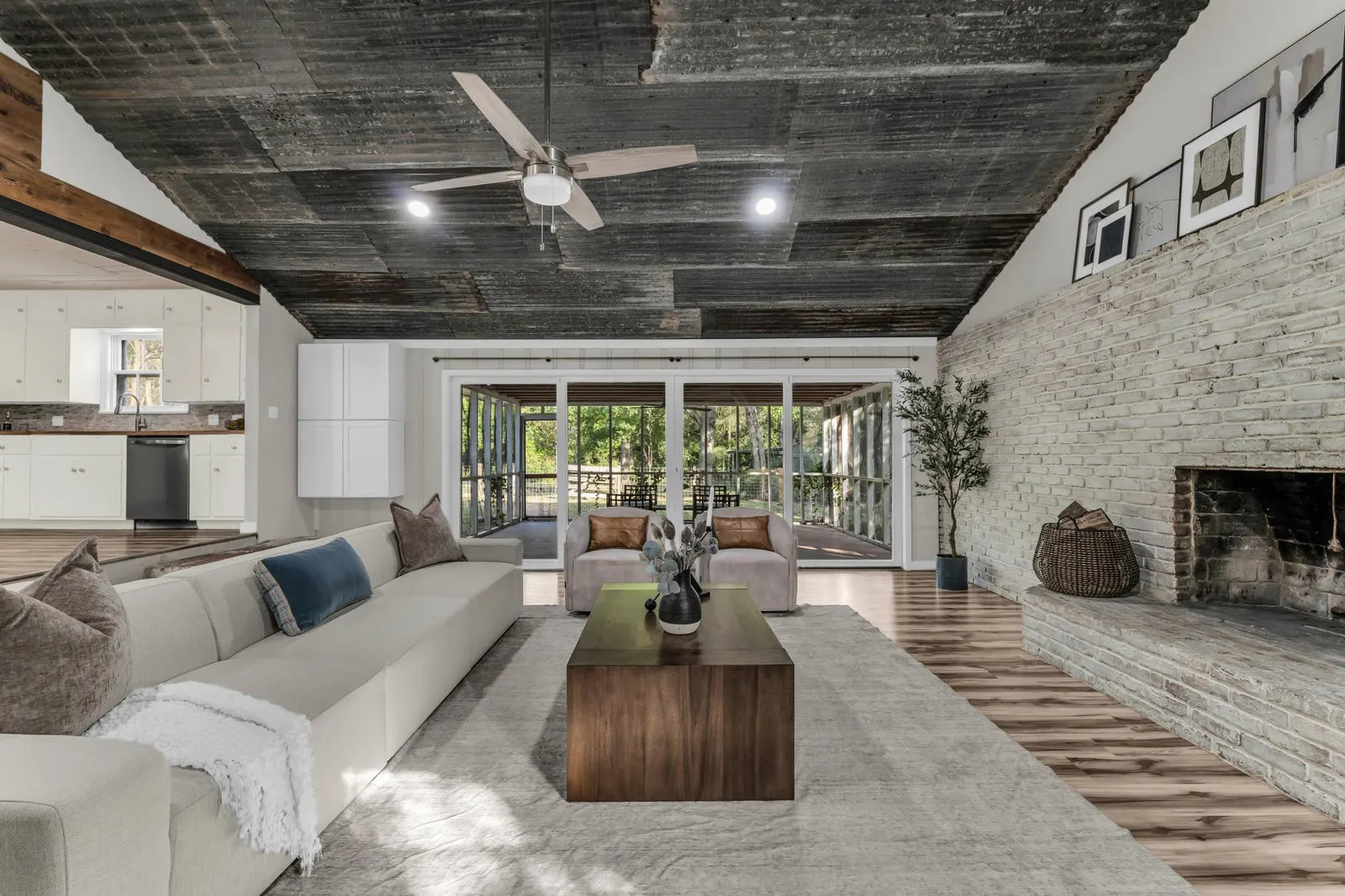 Wide-angle view of a farmhouse living room with a brick fireplace and shiplap accents.