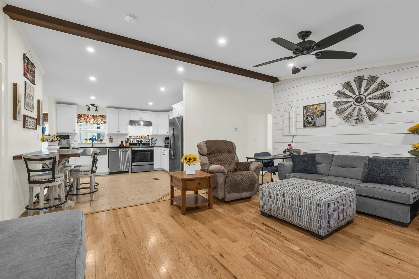 Eye-level view of a bright open living area with natural light and warm remodeled finishes.