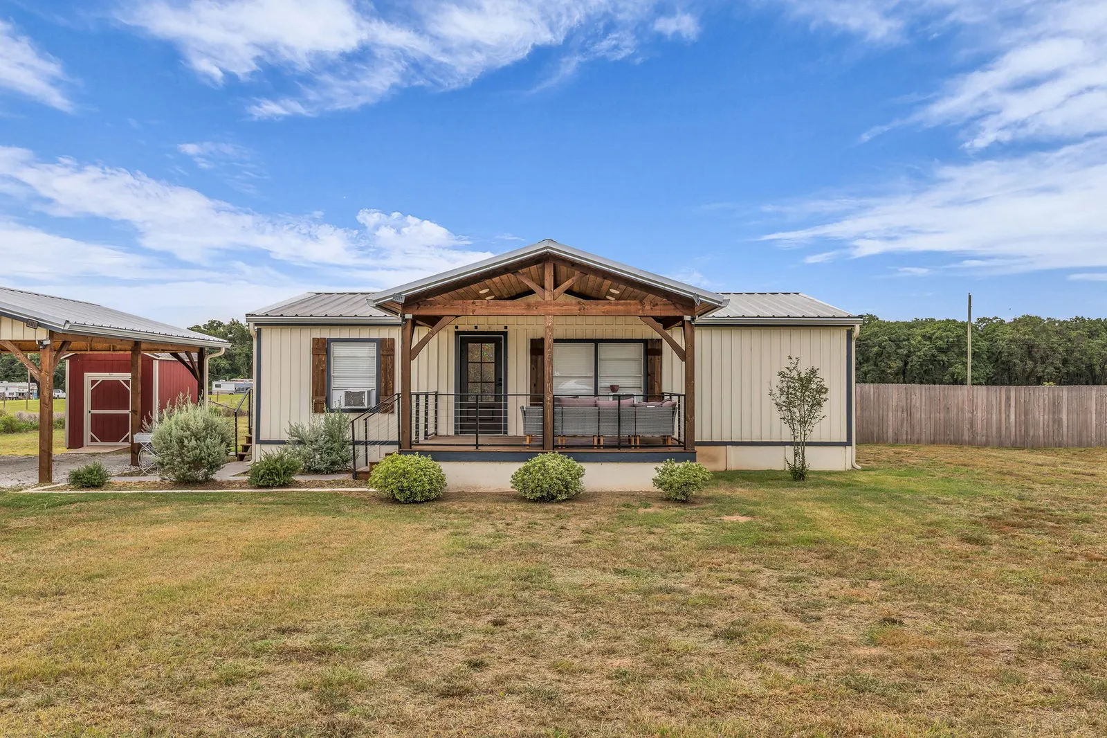 Wide-angle view of a remodeled home on a green acre with a welcoming front entry.